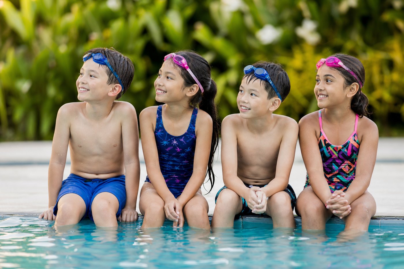 Children sitting on the pool edge listening to their coach